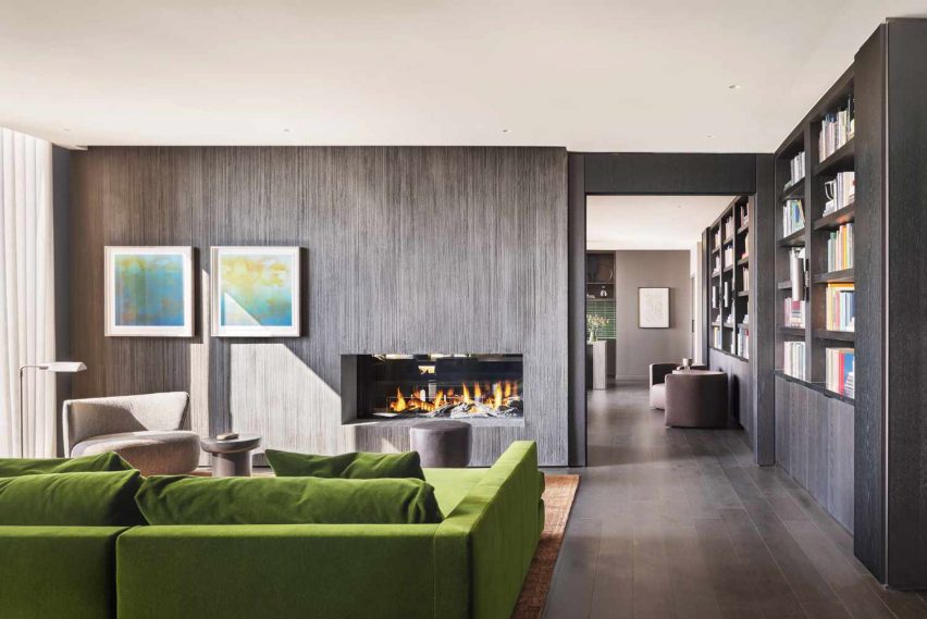 Green couch facing fireplace