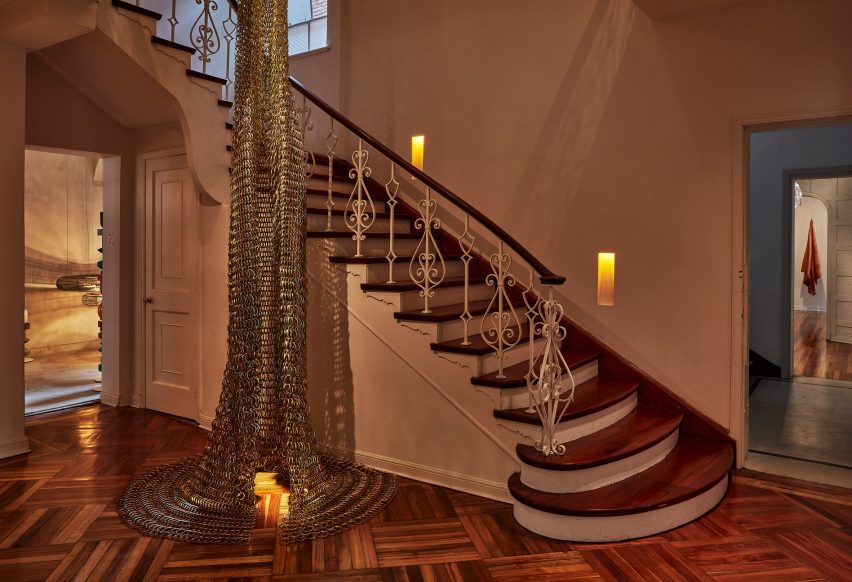 A staircase with metallic hanging art