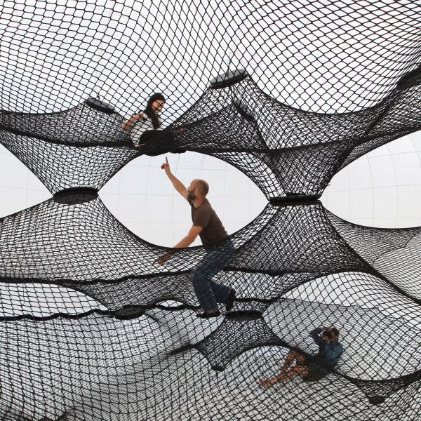 Photo of people climbing in a web installation
