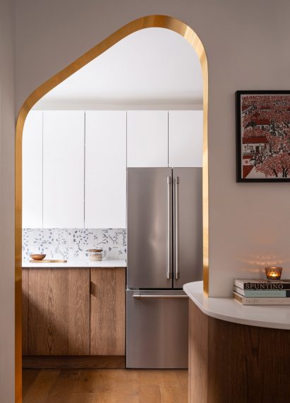 Open doorway with brass edges looking into the kitchen