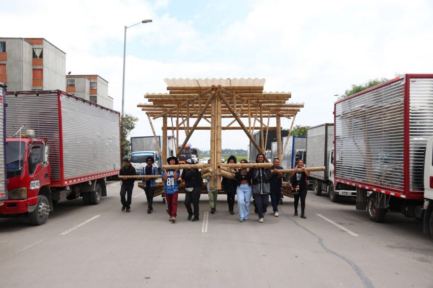 People carrying a bamboo structure