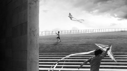 A striking photo of a boy flying a kite playing on the steps of the Teopanzolco Cultural Center in Mexico