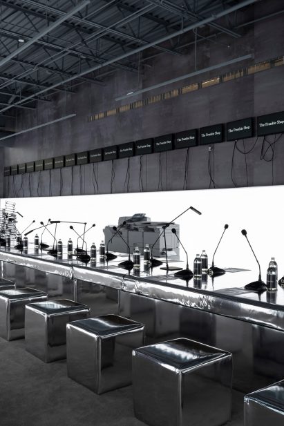 A long, metallic conference table within an industrial-style building