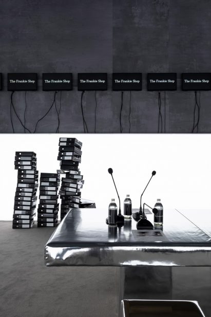 Metallic table with water bottles and microphones on top