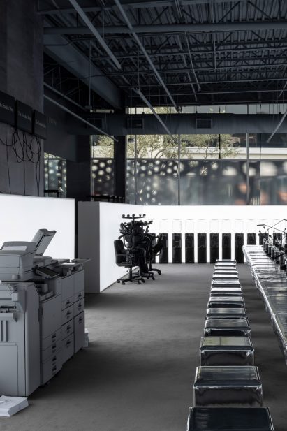 Equipment like printers, office chairs and water coolers arranged around a room