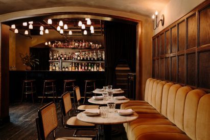 Downstairs area featuring dark-stained floors and a black marble bar counter