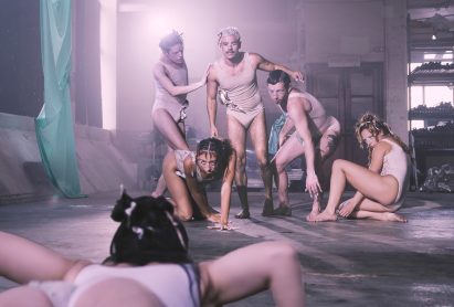 People dressed in skin-coloured outfits engaging in a dance performance