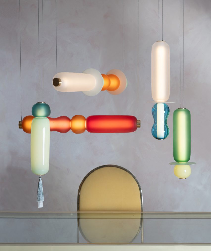 Photo of the Wave II pendant lights by Curiousa hanging above a table in a composition of horizontal and vertical designs that intersect