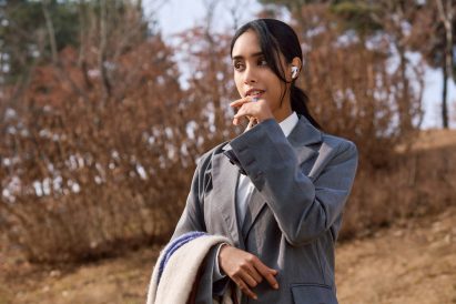 Photo of a young woman in business attire with her hand raised to her mouth to use her WIZPR smart ring