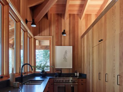 A kitchen that is lined by windows