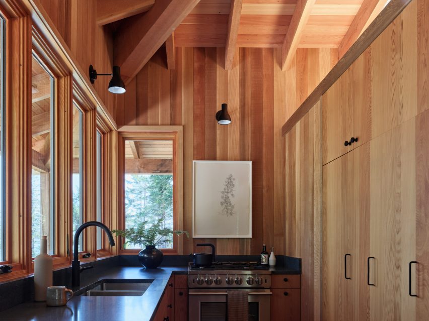 A kitchen that is lined by windows