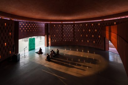 Worshippers sitting inside the prayer hall of the Zebun Nessa Mosque by Studio Morphogenesis