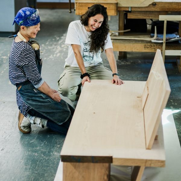 Photo of people looking at a wooden bench