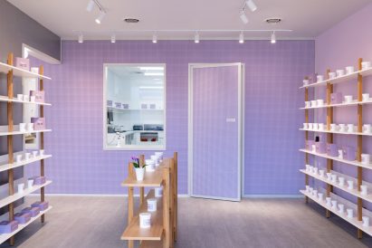 Oak-framed shelving displays products in a mauve room