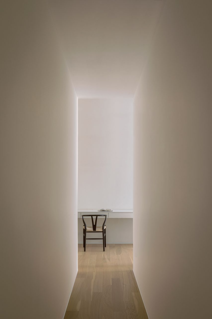 White hallway with wish bone chair at end