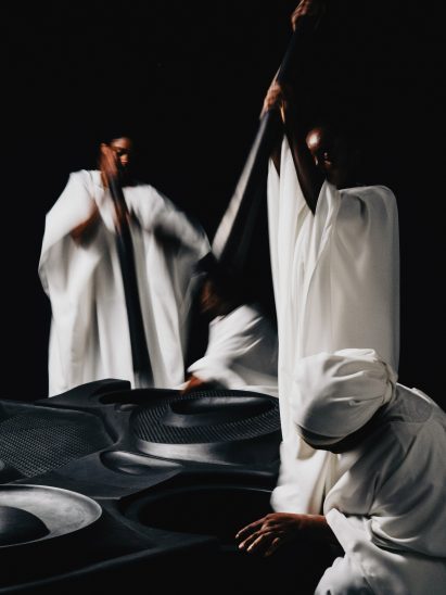 People miming the act of making fufu on Communion table by Giles Tettery Nartey