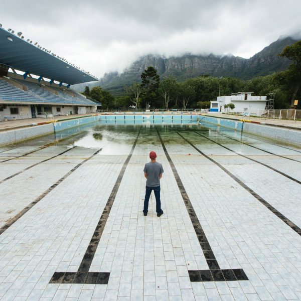 Photo of man standing in near-empty Newlands municipal swimming pool in Cape Town by Bloomberg via Getty Images