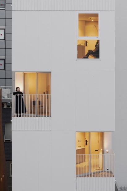 People looking out from balconies of Japanese building