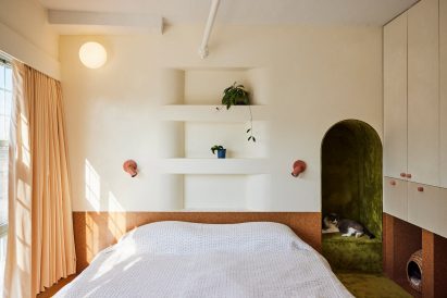 Light-filled bedroom featuring cork wainscoting and plenty of built-in storage