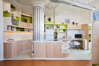 Kitchen in a loft apartment with tambour lower cabinets that curve around an island