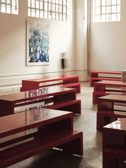 Office dining area furnished with red tables by Holloway Li