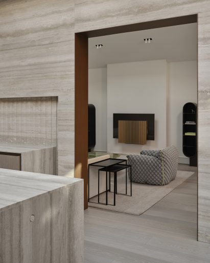 Doorway from a travertine-lined kitchen to a living room