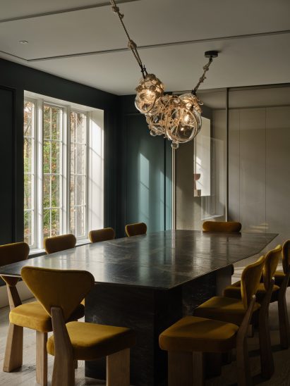Dining room with teal walls and a knotted chandelier over the table