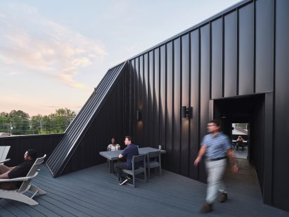 Black clad structure with people walking around it