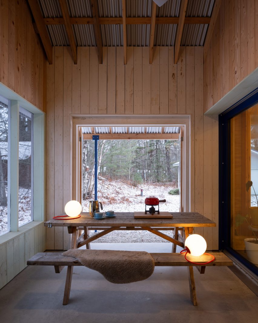 A picnic table inside a porch area