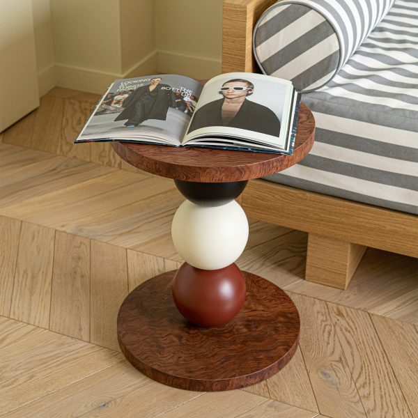 Photo of book on a side table in front of a stripe sofa