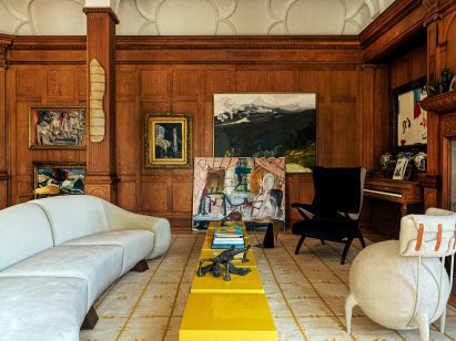 Living room with walnut panelling, bold furniture and lots of artwork