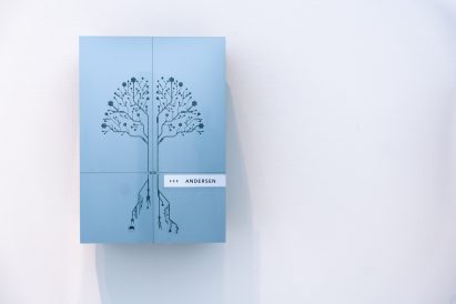Blue wall-mounted charging point decorated with a tree-like design