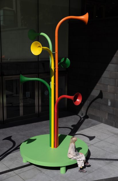 Exterior view of Arborhythm installation by Yuri Suzuki, with a person sat at the base