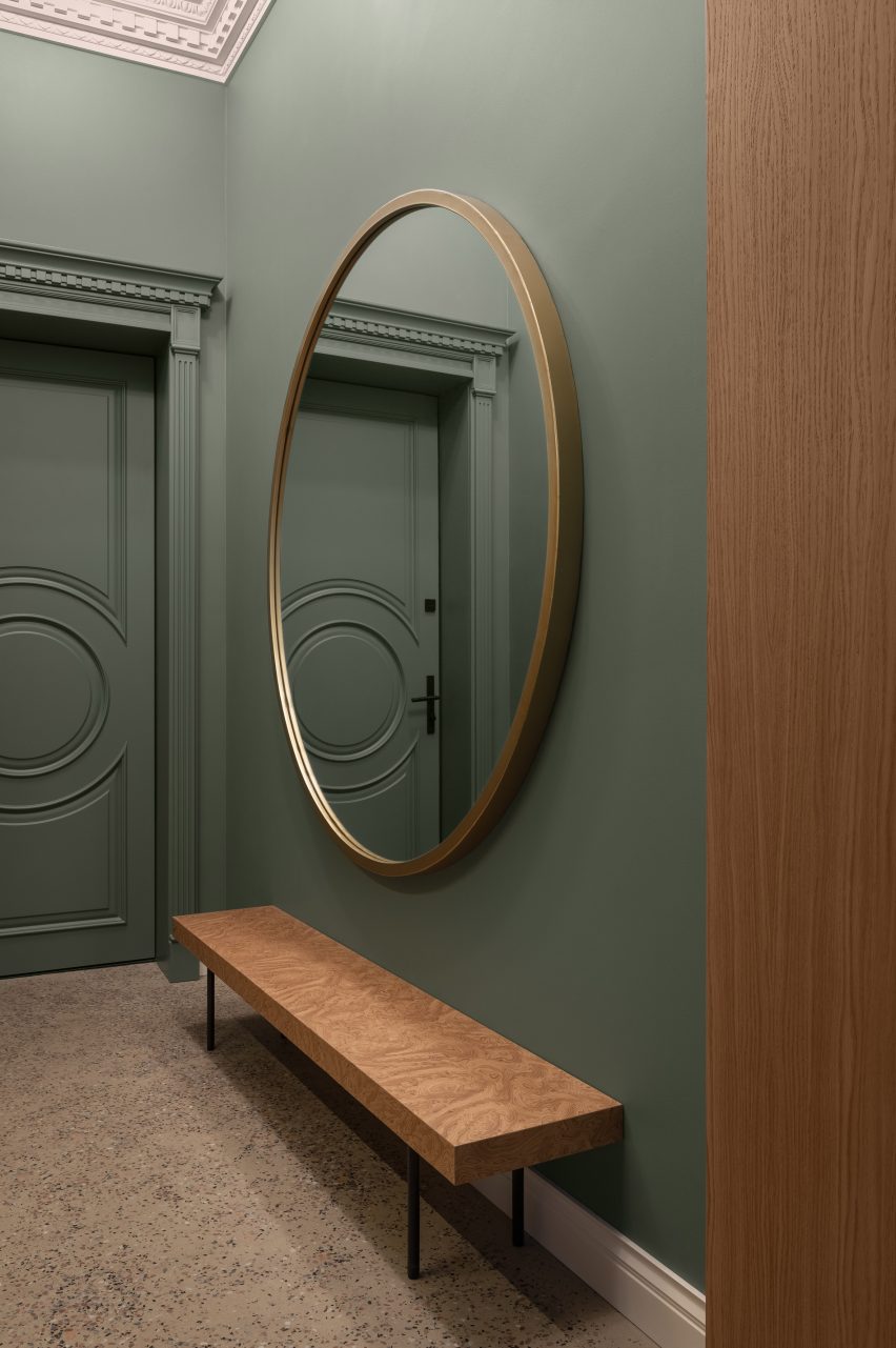 Entryway of BH apartment has a large round mirror