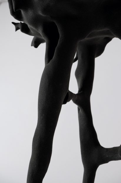 Close-up photo of the Digested Objects stool showing tunnels and pits in the surface