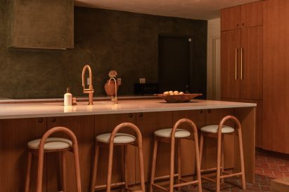 Kitchen with dark green plaster walls and warm millwork