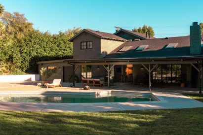 Exterior of a house with a large veranda in front of a swimming pool