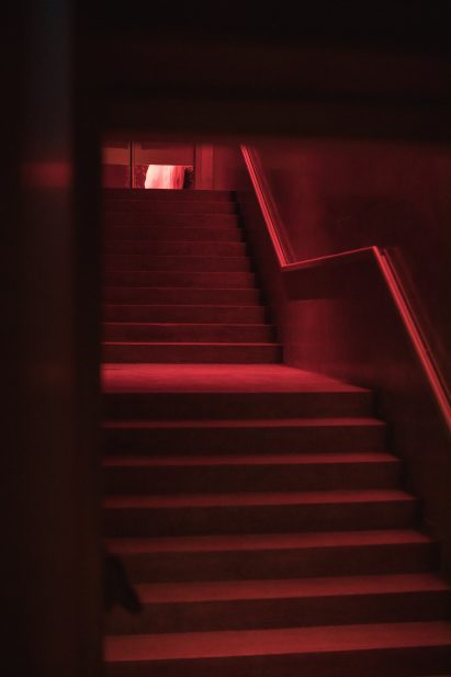 Staircases illuminated in red lead down to the dance floor