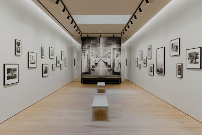 A photography gallery with white walls and pale wood flooring