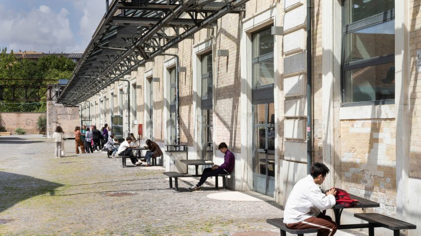 Students sitting down next to building