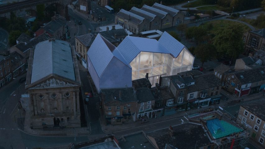 An image showing a bird's eye view of a city, with a large white illuminated building.