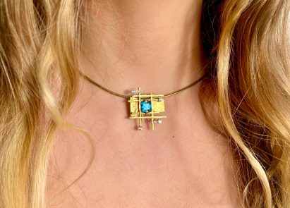 Model wearing necklace with gold pendant
