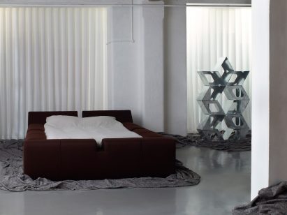 Large bed and metal sculpture at London design exhibition