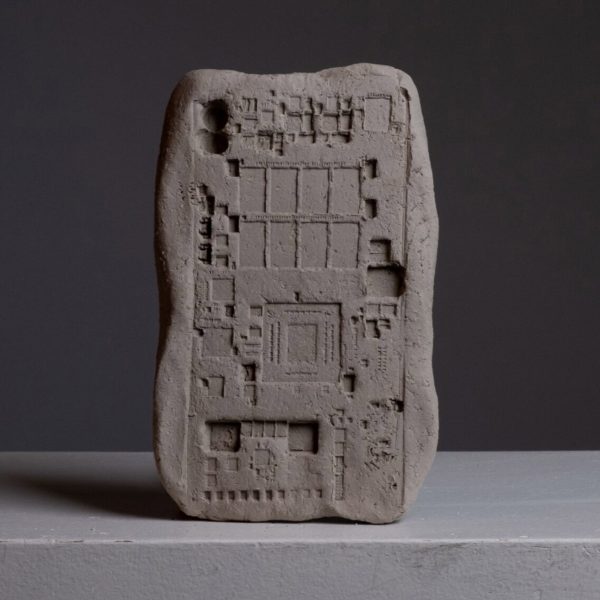 An image of a grey clay block on a grey surface with squares printed onto it.