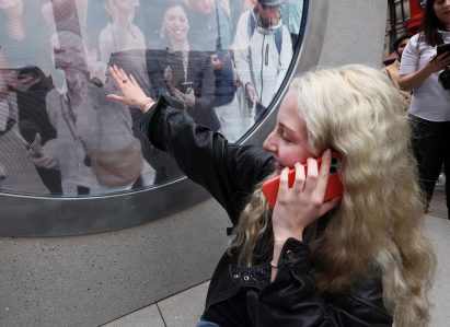 Woman touching screen of portal installation