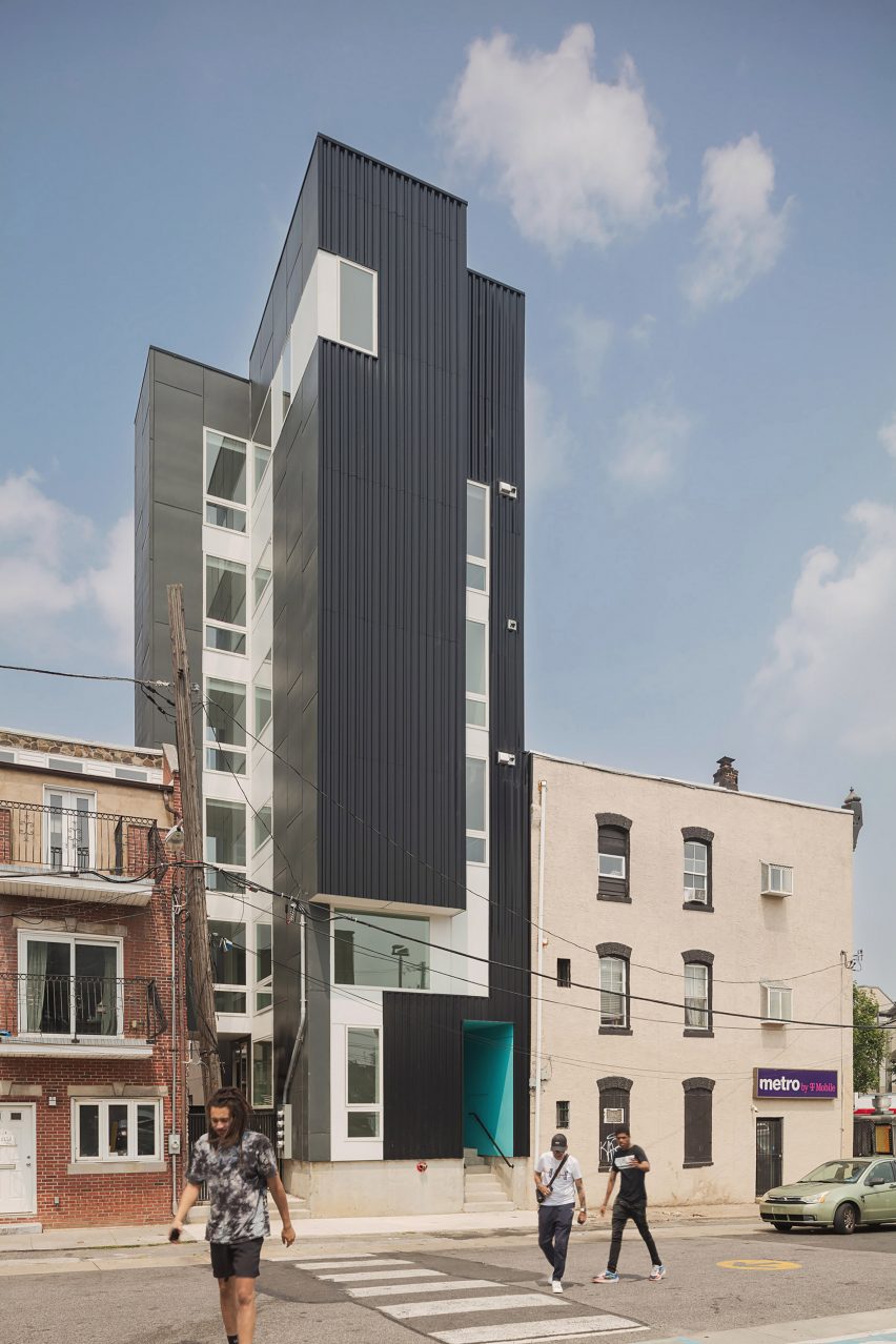 A tall building slated between others