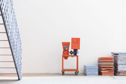 Recycling machine next to stacks of recycled plastic sheets