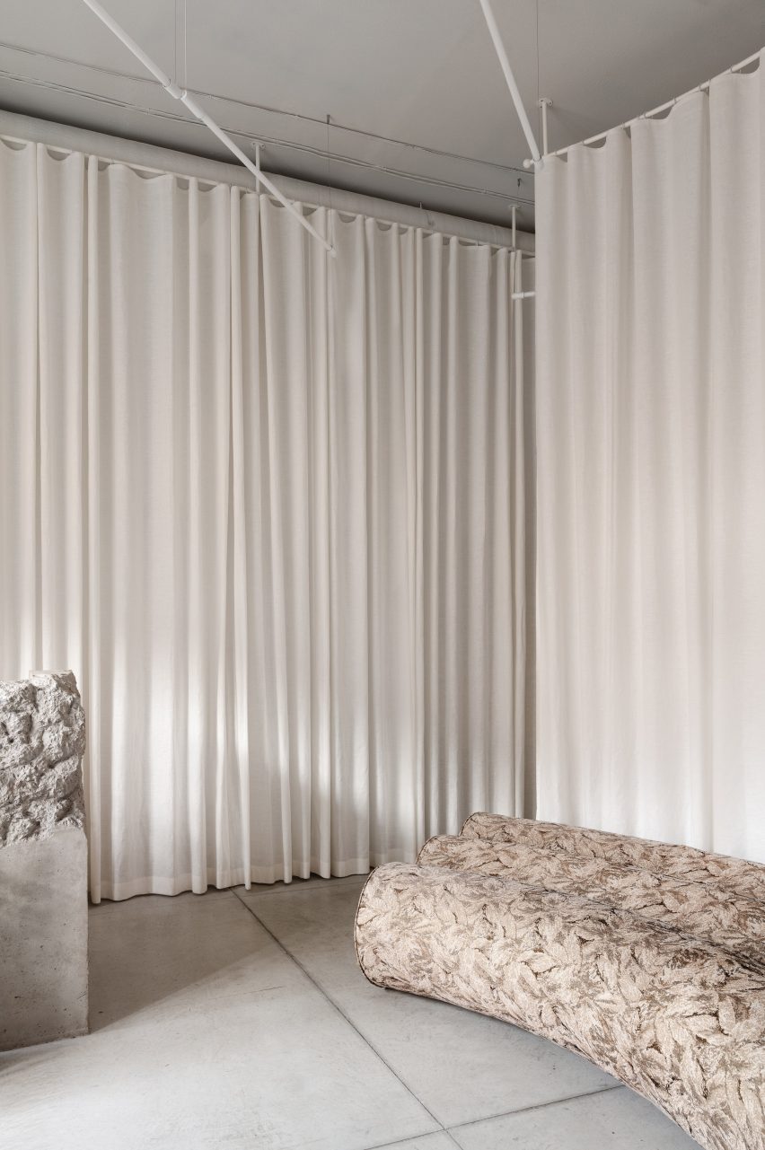 A curving couch in front of curtains