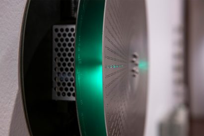 A close up perspective of a silver and green machine made of metal.