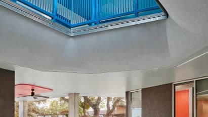 Woman walking under blue staircase